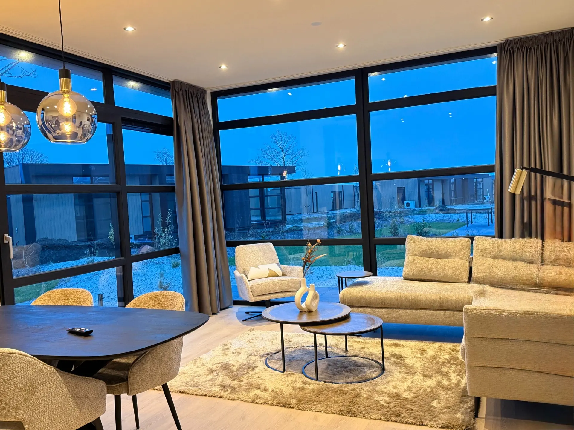 Living room with floor-to-ceiling windows and garden view at Villa Meerzicht, Workum.